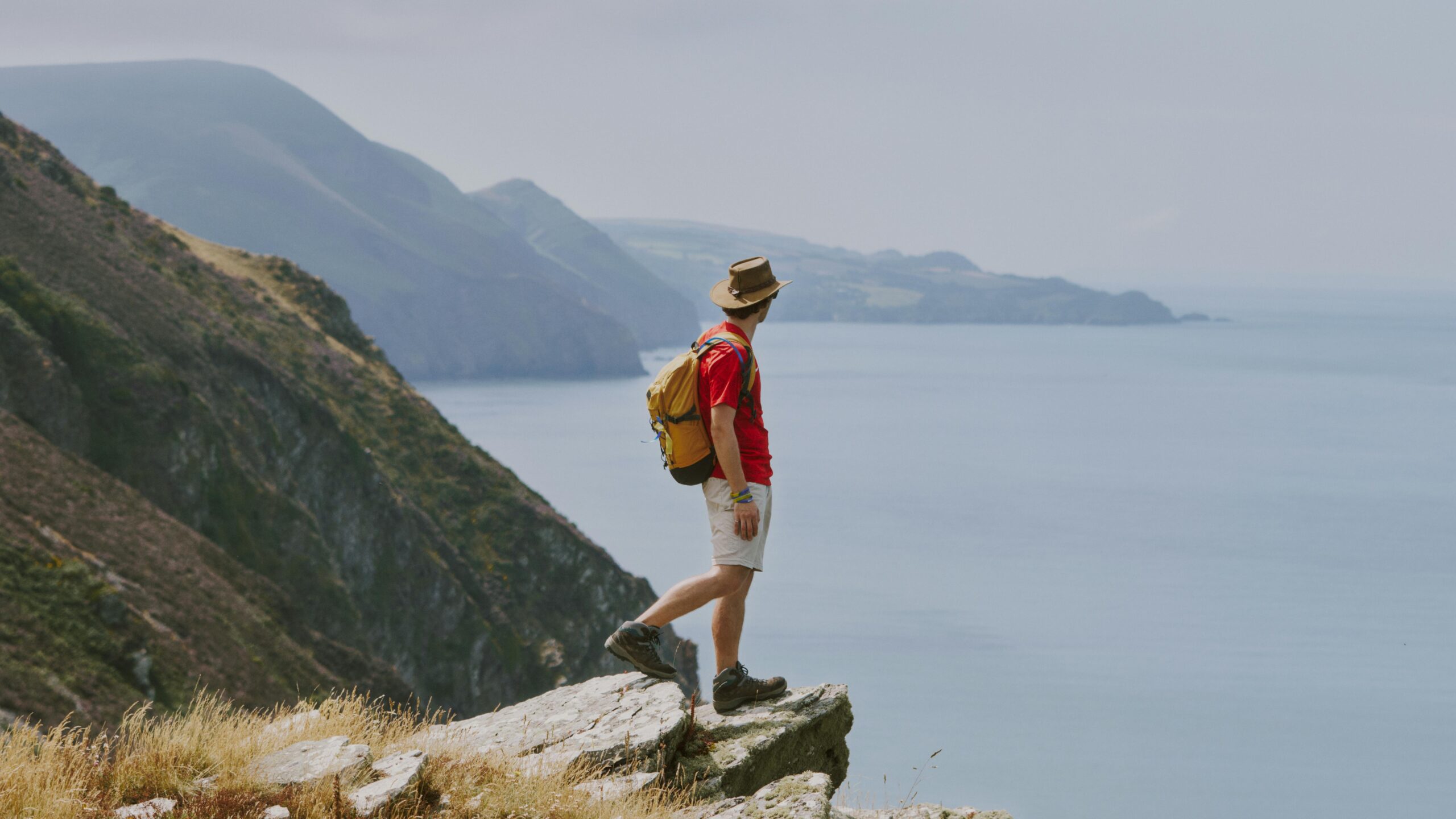 A hiker enjoys a scenic view on the cliffs of Lynton, England, embracing the adventure and beauty of nature.